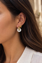 Boucles d’oreilles mini créoles dorées Veronika M ornées d’un pendentif donut en nacre - Bijou porté