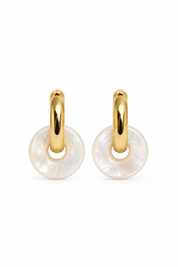 Boucles d’oreilles mini créoles dorées Veronika M ornées d’un pendentif donut en nacre - Bijou sur fond blanc