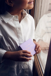 Petite fille qui tient un écrin à bijou Chloe Rose de couleur lila en souriant