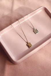 Médaille en argent Rosalie carrée avec bordure perlée et étoile sertie d'un zircon pour gravure - Bijou photographié dans une coupole rectangulaire rose
