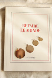 Médaille ronde simple dorée pour gravure Alba L - Bijou photographié sur un livre
