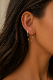Boucle d'oreille monoboucle Aurora à l'unité dorée créoles ornées de zircons reliées par une chaîne - Bijou porté