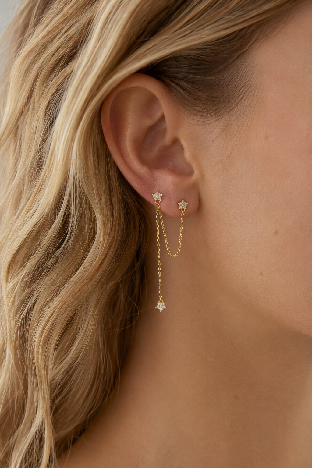 Boucle d'oreille monoboucle Nina à l'unité dorée ornée d'étoiles serties de zircons et de chaînes - Bijou porté