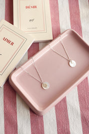 Pendentif rond en nacre à personnaliser avec lettre de l'alphabet ou charm - Bijou photographié dans une coupole rectangulaire rose