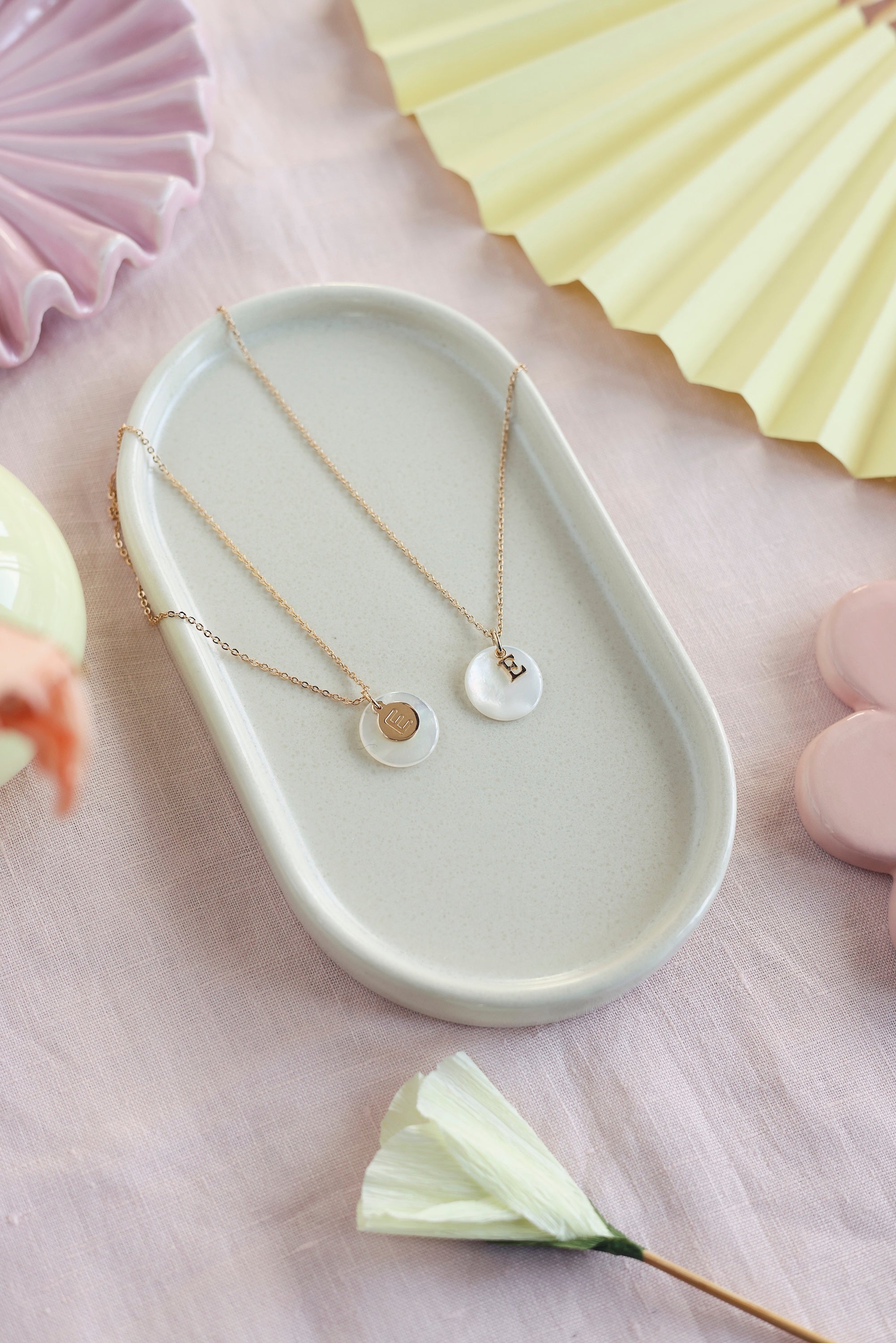 Pendentif rond en nacre à personnaliser avec lettre de l'alphabet ou charm - Bijou photographié dans une coupole blanche 